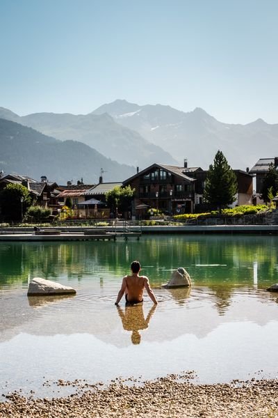 Une personne est assise dans l'eau au bord du lac