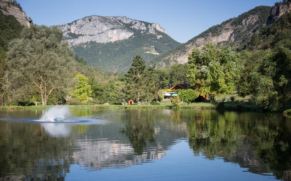 Le lac en premier plan reflète les montagnes environnantes sous un ciel ensoleillé tandis qu’au fond apparaissent la [...]