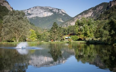 Le lac en premier plan reflète les montagnes environnantes sous un ciel ensoleillé tandis qu’au fond apparaissent la [...]