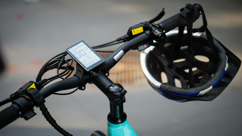 Vélo électrique avec casque, borne recharge en Ardèche