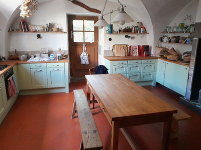 On se retrouve dans une cuisine voutée toute blanche avec des meubles bas de rangement et grands plans de travail. Des [...]