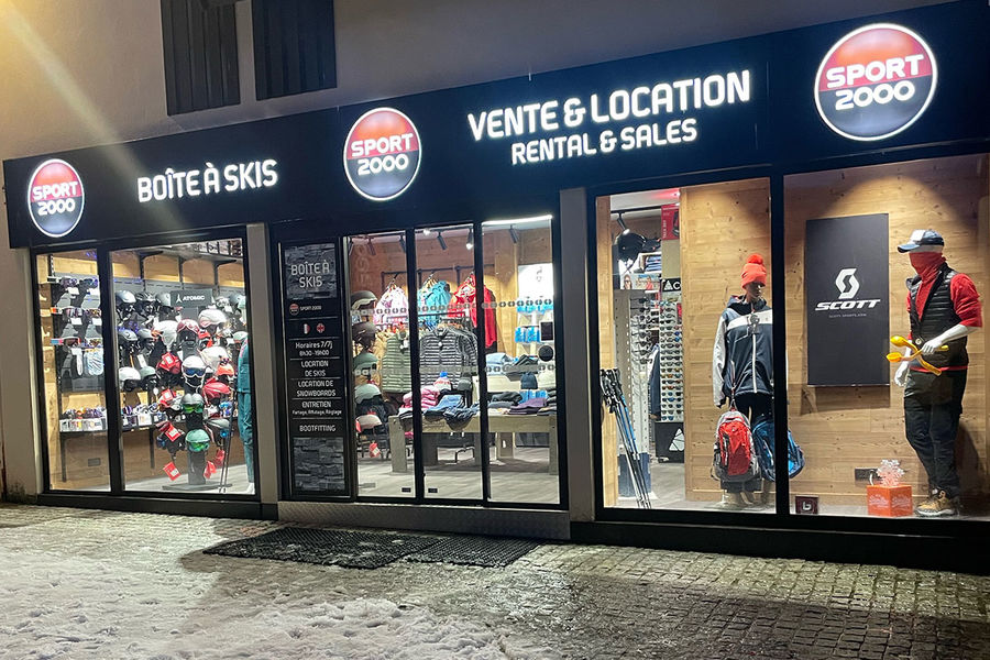 Façade du magasin Sport 2000 avec vitrine dans lesquels sont exposés les vétements en vente ainsi que le matériel louable [...]