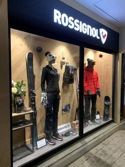Façade avec logo rossignol au dessus de la vitrine avec vétements de la même marque.