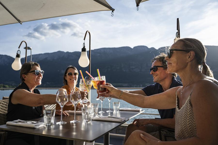 amis à l'apéritif sous parasol vue sur le lac d'annecy