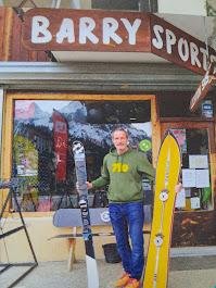Patrick avec des skis skwal devant la boutique