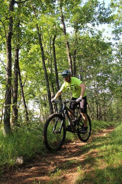 Un VTTiste roulant sur un single en sous-bois